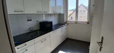 moderne Küche mit Kühlschrank, Mikrowelle und Backofen