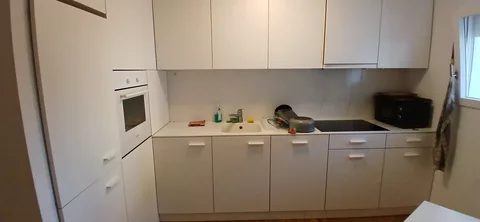 moderne Küche mit Kühlschrank, Mikrowelle und Backofen