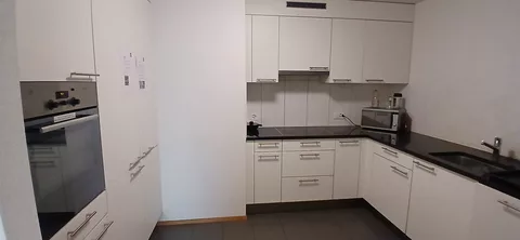 moderne Küche mit Kühlschrank, Mikrowelle und Backofen