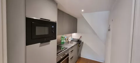 moderne Küche mit Kühlschrank, Mikrowelle und Backofen