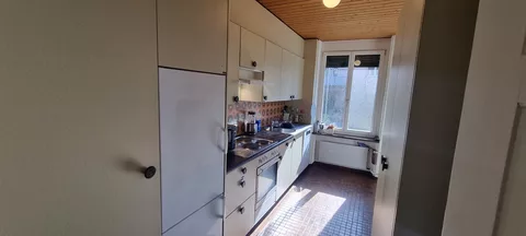 moderne Küche mit Kühlschrank, Mikrowelle und Backofen
