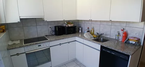 moderne Küche mit Kühlschrank, Mikrowelle und Backofen