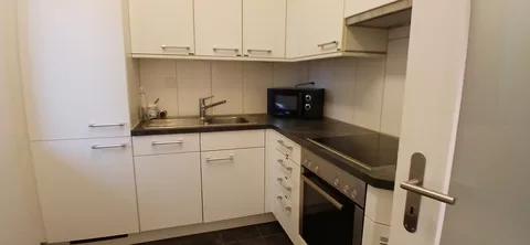 moderne Küche mit Kühlschrank, Mikrowelle und Backofen
