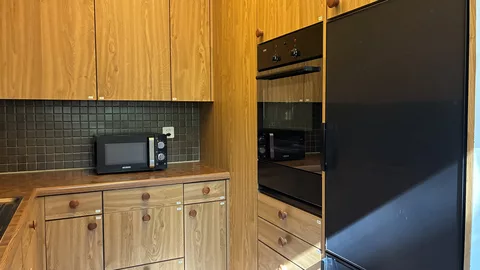 moderne Küche mit Kühlschrank, Mikrowelle und Backofen