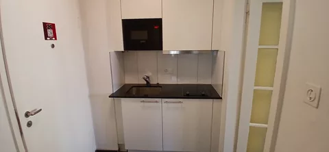moderne Küche mit Kühlschrank, Mikrowelle und Backofen